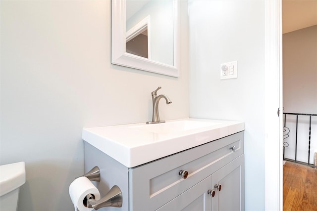 bathroom with vanity, toilet, and wood finished floors