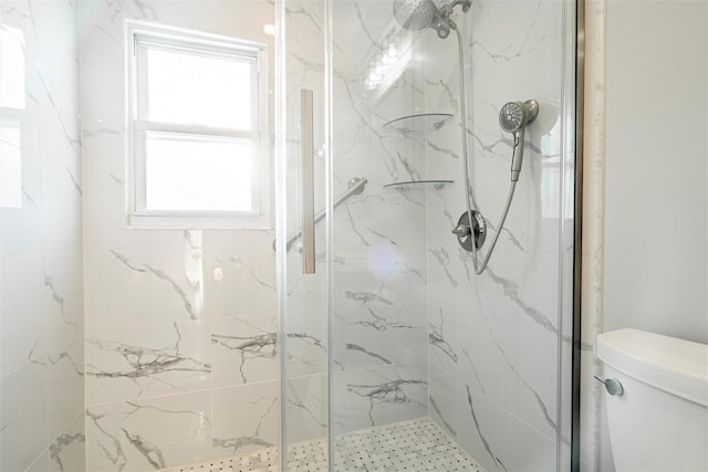 full bathroom featuring toilet and a marble finish shower