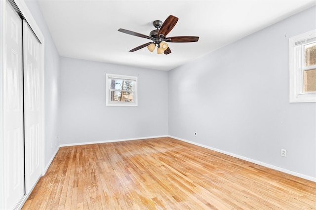 spare room featuring baseboards, light wood finished floors, and a healthy amount of sunlight