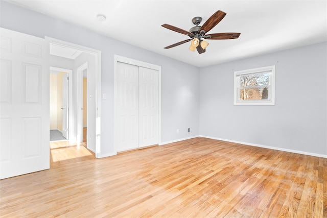 unfurnished bedroom featuring a closet, light wood-type flooring, a ceiling fan, and baseboards