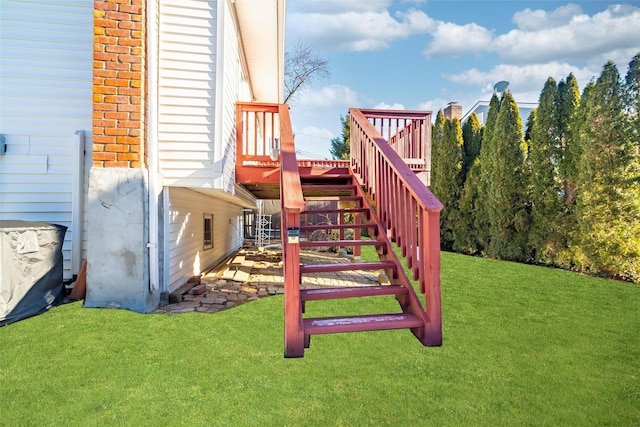 view of playground with stairway, a deck, and a yard