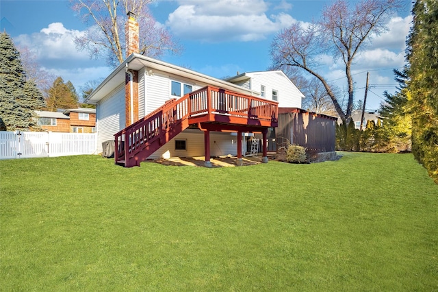 back of property with stairs, fence, a deck, and a yard