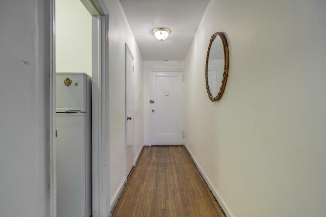 hall with hardwood / wood-style flooring and baseboards