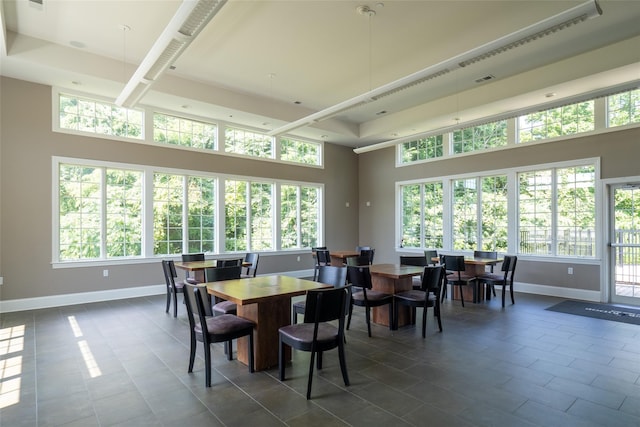 tiled dining space featuring a high ceiling and plenty of natural light