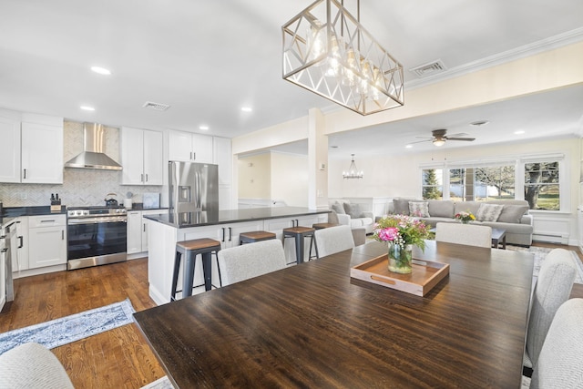 dining area featuring dark wood-style floors, a baseboard radiator, visible vents, and ornamental molding