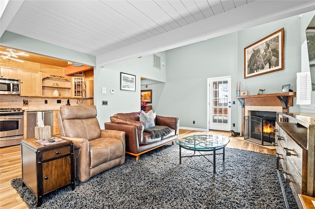 living room featuring beam ceiling, light hardwood / wood-style floors, and wooden ceiling