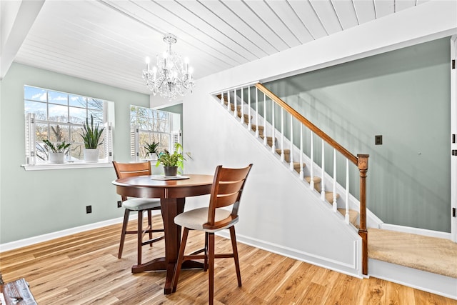 dining space with light hardwood / wood-style floors, a chandelier, and wooden ceiling