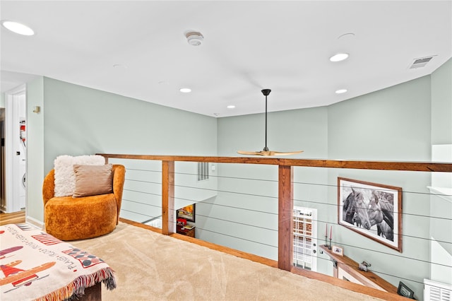 living area with carpet and ceiling fan