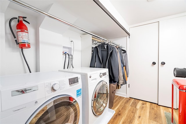 laundry room with independent washer and dryer and light wood-type flooring