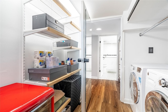 clothes washing area featuring hardwood / wood-style flooring and independent washer and dryer