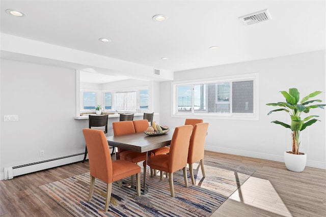 dining space featuring light wood-type flooring and a baseboard radiator