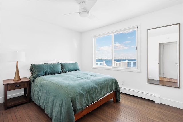 bedroom featuring ceiling fan, a water view, dark wood-type flooring, and a baseboard heating unit