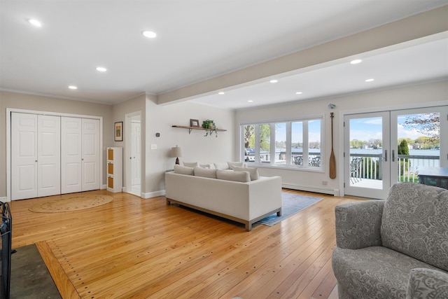 living room featuring a baseboard heating unit, baseboards, light wood-type flooring, recessed lighting, and french doors