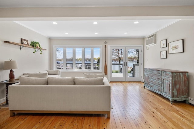 living room featuring recessed lighting, a water view, a wall unit AC, and light wood-style floors