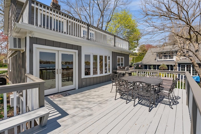 wooden terrace featuring outdoor dining space, french doors, and a grill