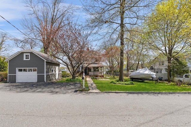 view of front facade with a garage, an outdoor structure, and a front lawn