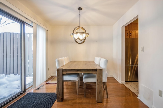 dining area with hardwood / wood-style flooring and a chandelier