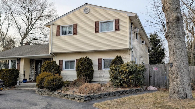 view of front facade featuring aphalt driveway and fence