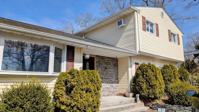 view of front of house with a wall mounted AC