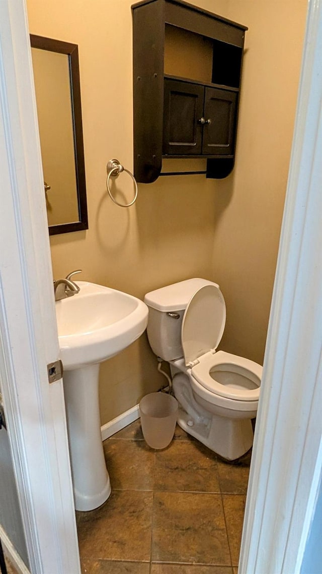 half bathroom with toilet and baseboards