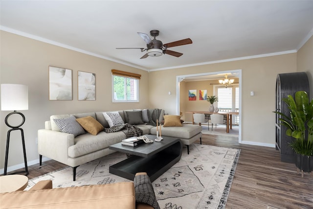 living area with a chandelier, baseboards, a ceiling fan, wood finished floors, and crown molding