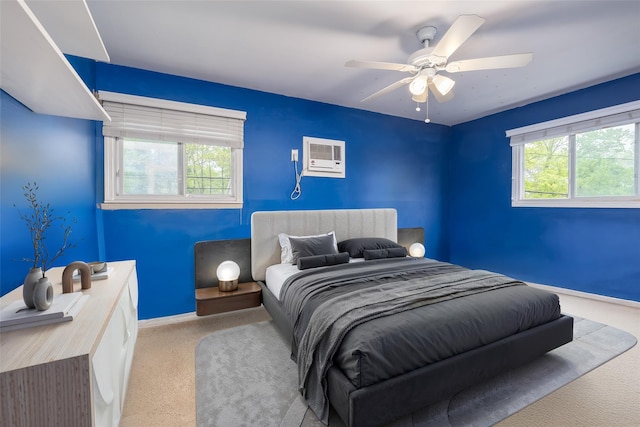 carpeted bedroom featuring baseboards, a ceiling fan, and an AC wall unit
