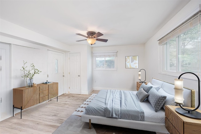 bedroom with light wood-type flooring, ceiling fan, and baseboards