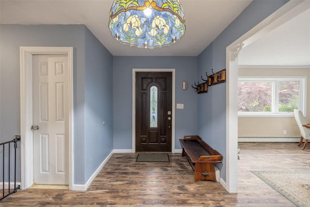 foyer entrance featuring a baseboard radiator, wood finished floors, baseboards, and a chandelier