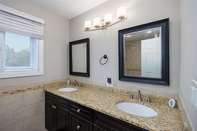 bathroom with double vanity, tile walls, and tiled shower