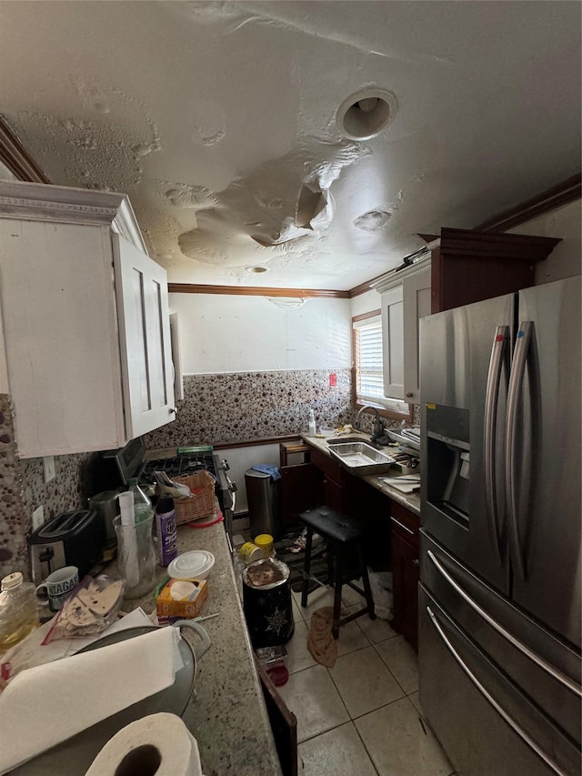 kitchen featuring white cabinets, light tile patterned floors, sink, and stainless steel fridge with ice dispenser