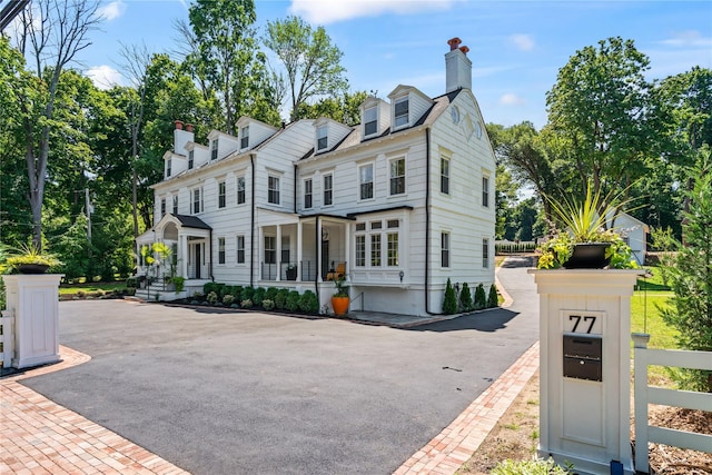 view of front of house featuring covered porch and a chimney