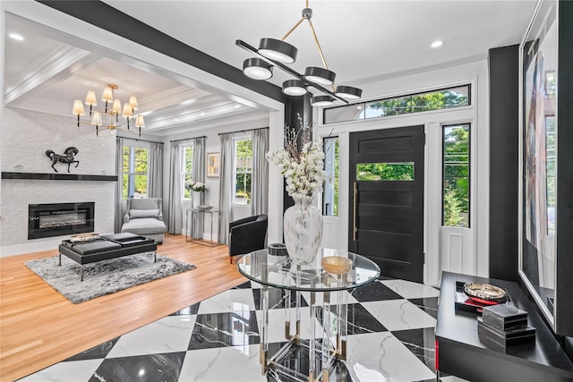 living room with crown molding, an inviting chandelier, a large fireplace, wood finished floors, and coffered ceiling