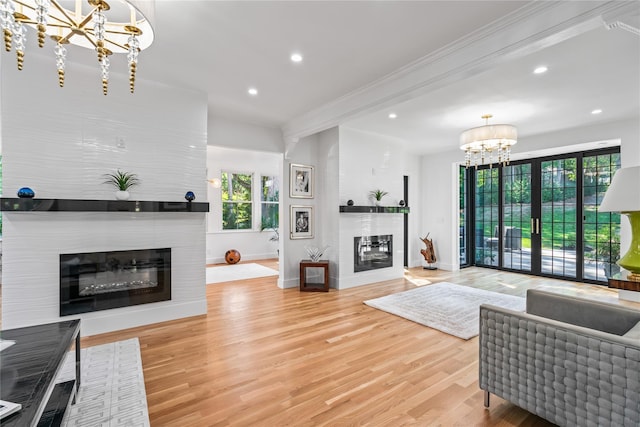 living area featuring recessed lighting, a notable chandelier, a fireplace, wood finished floors, and baseboards