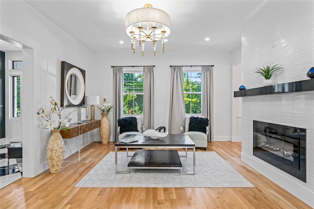 dining space with recessed lighting, a notable chandelier, a fireplace, wood finished floors, and baseboards