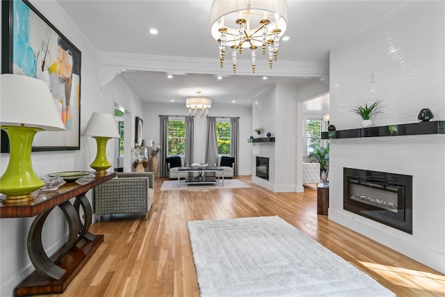 living area with a large fireplace, recessed lighting, wood finished floors, and an inviting chandelier