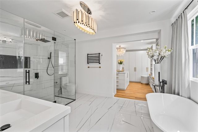 bathroom featuring a stall shower, marble finish floor, a freestanding tub, and recessed lighting