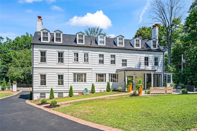 view of front of property featuring a chimney and a front lawn