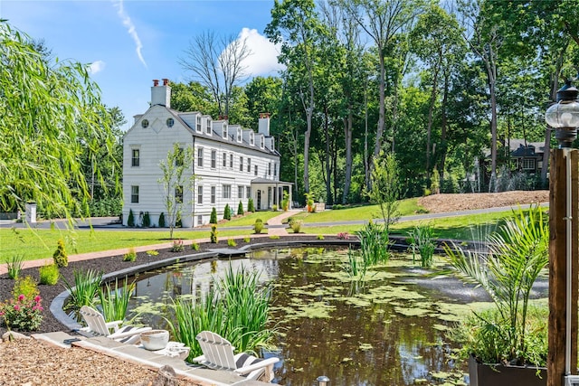 exterior space with a small pond and a lawn