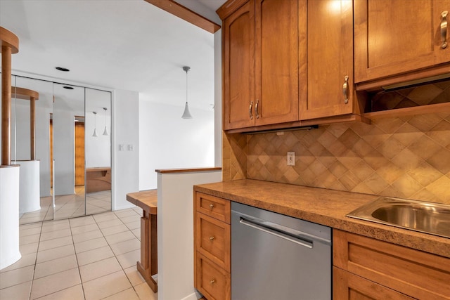 kitchen with hanging light fixtures, light tile patterned floors, decorative backsplash, brown cabinetry, and dishwasher