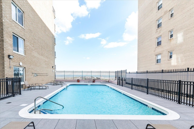 community pool featuring a patio area and fence