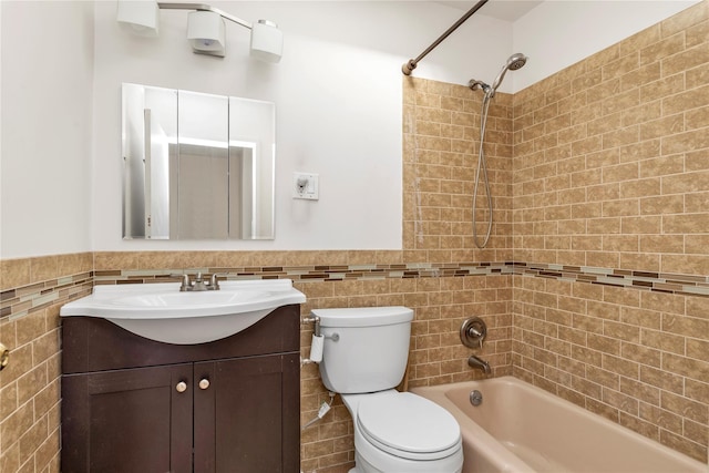 full bathroom with tile walls, shower / bathing tub combination, toilet, wainscoting, and vanity