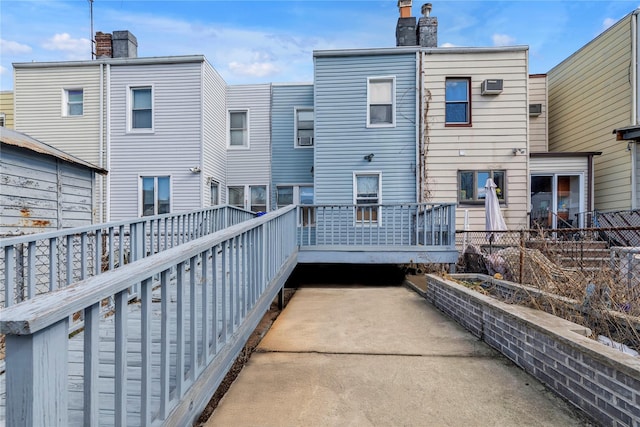 rear view of property with a chimney and a wooden deck