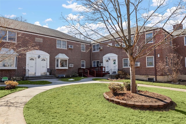 view of front of home featuring brick siding and a front lawn