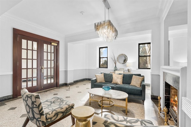 living area featuring light speckled floor, french doors, a fireplace, ornamental molding, and baseboards