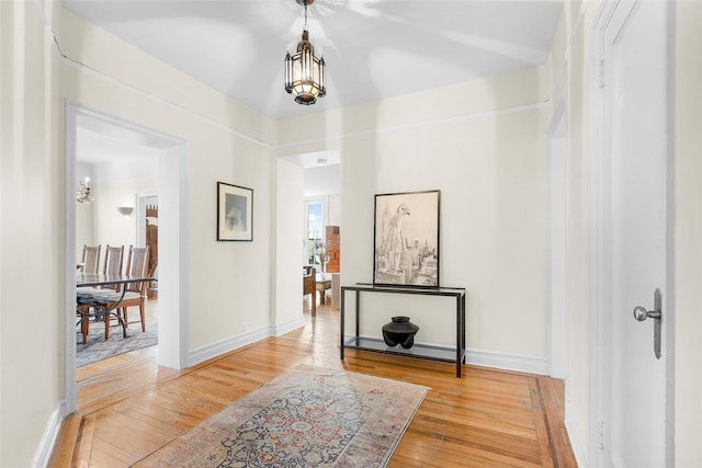 hallway with light wood-type flooring and baseboards