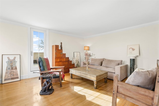 living area featuring light wood-type flooring and crown molding