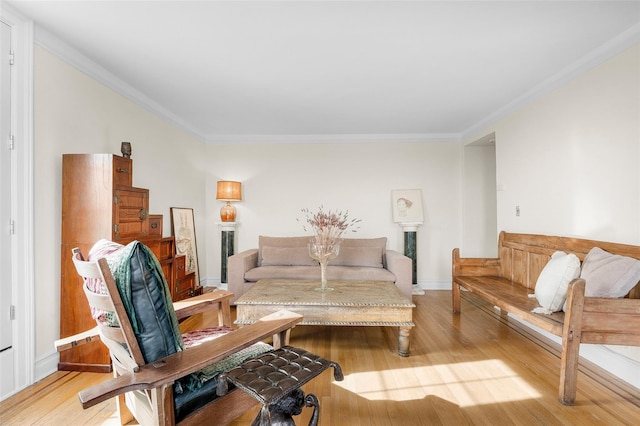 living room with light wood-style floors, crown molding, and baseboards