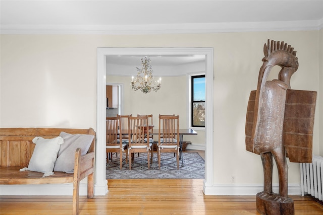 dining space with radiator, wood finished floors, and crown molding