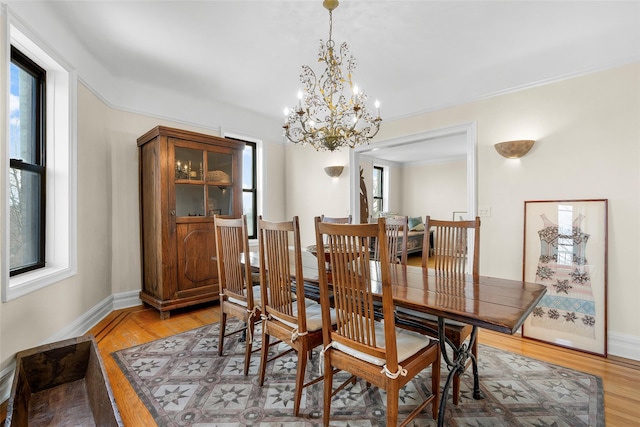 dining area featuring crown molding, wood finished floors, and baseboards