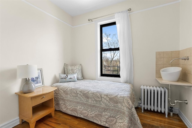 bedroom featuring dark wood-style floors and radiator